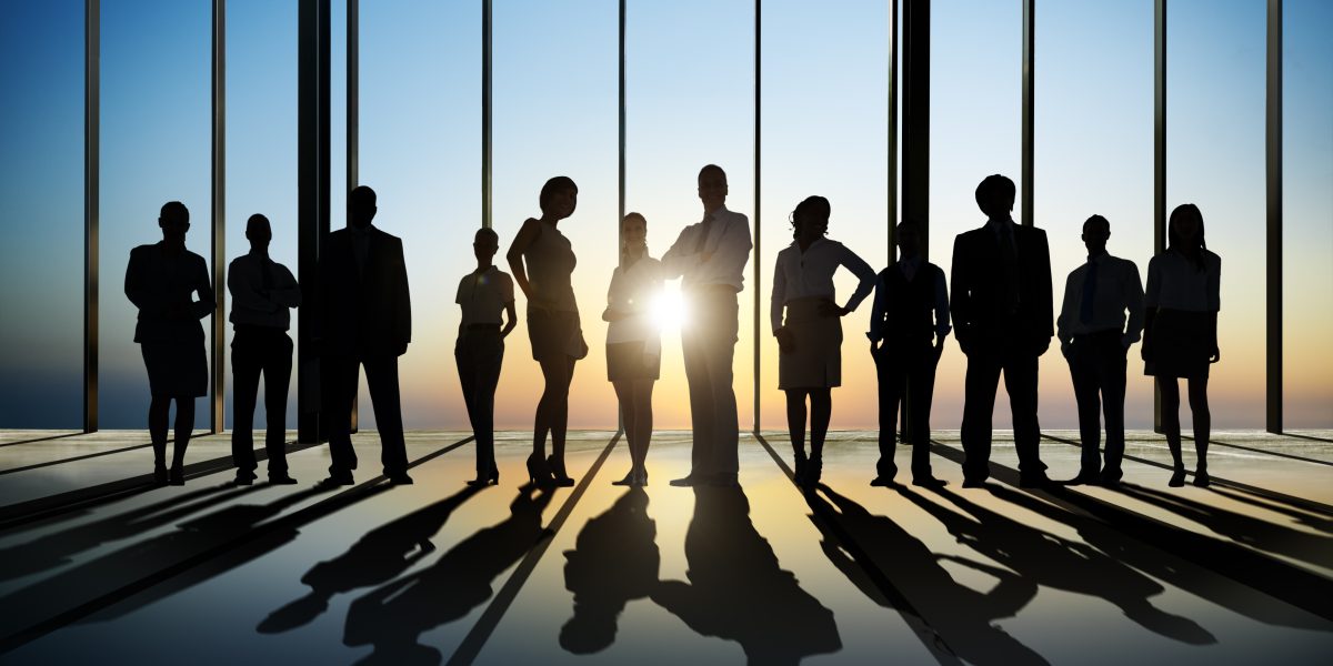 silhouette,of,business,people,posing,by,window